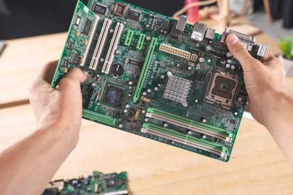 close-up-it-male-technician-holding-computer-mainboard_23-2147883880